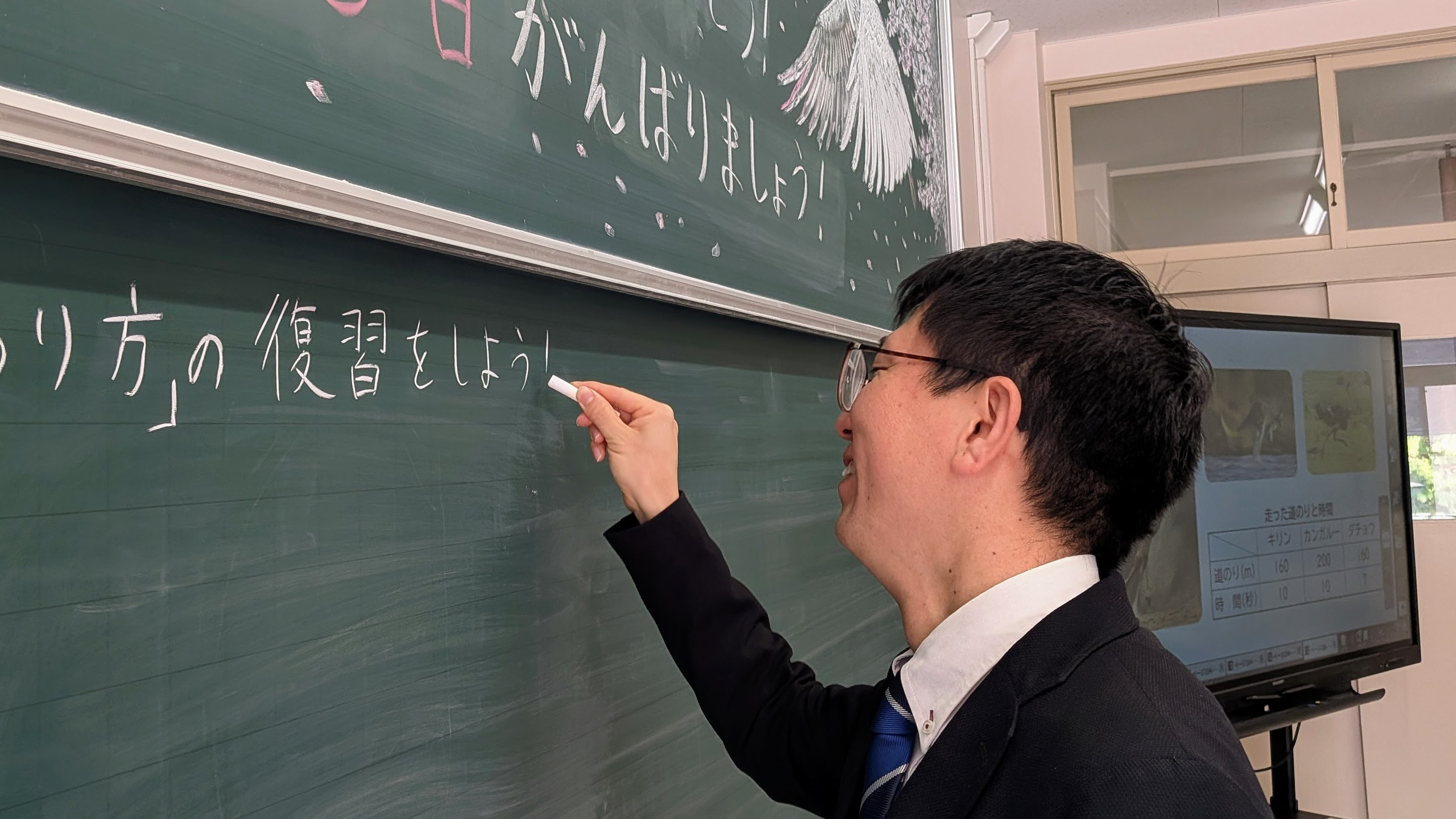 黒板に向かい板書をする木村先生の横顔